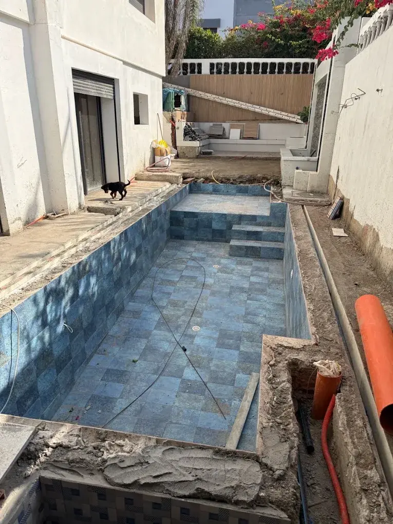 Swimming pool tiles in rough condition with calcium deposits and grout damage in Dubai